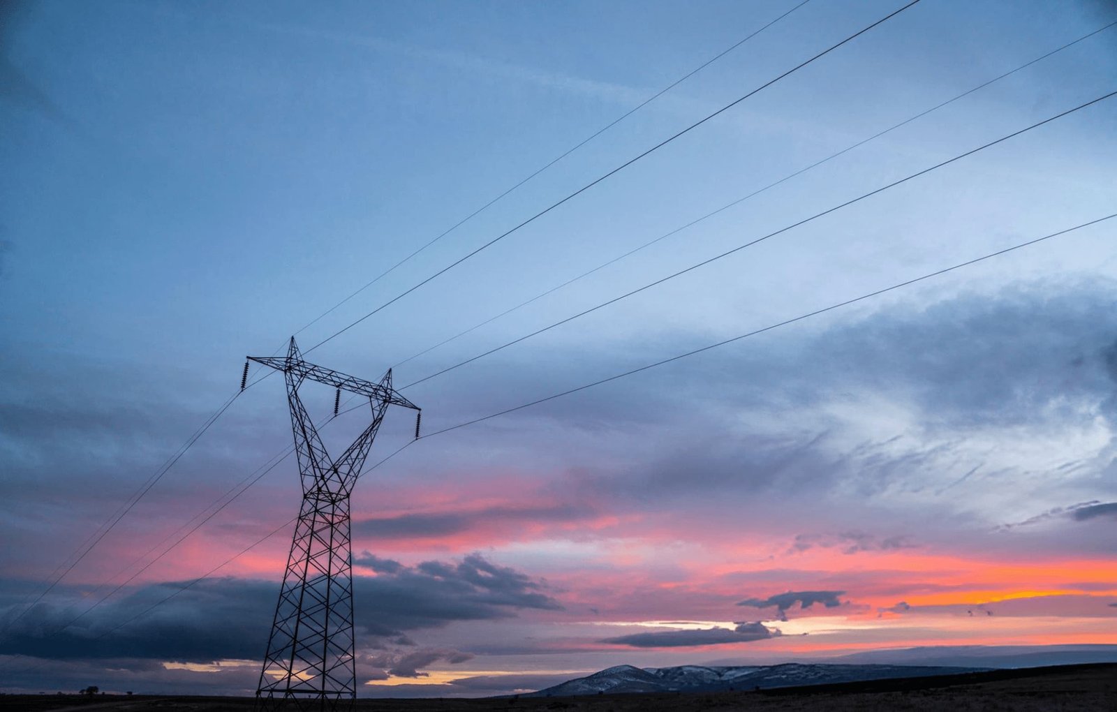 Overhead transmission line running to the horizon at dusk