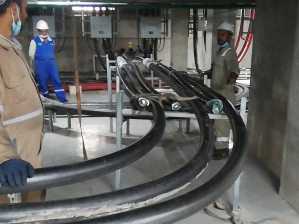 Technicians routing high-voltage power cables inside a cable basement